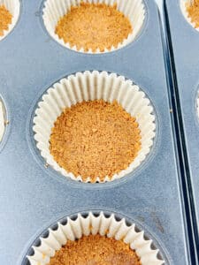 Biscoff cookie crusts pressed down in muffin liners.