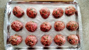 A sheet pan with The Best Italian Meatballs on it before they've baked