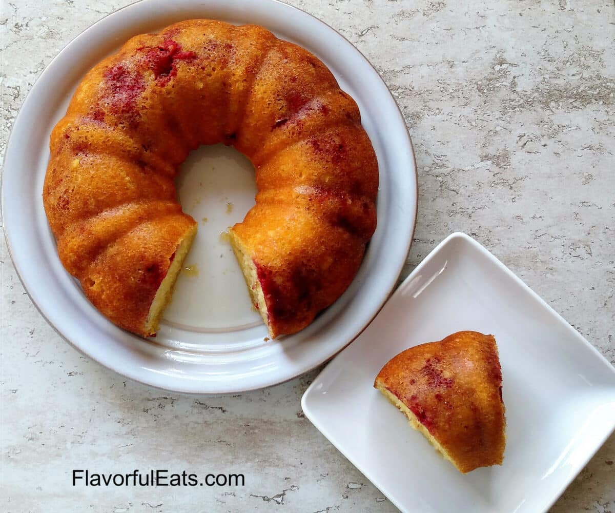 Lemon Raspberry Bundt Cake on a plate with a slice cut out beside it on another plate.