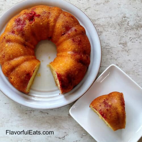 Lemon Raspberry Bundt Cake on a plate with a slice cut out beside it on another plate.