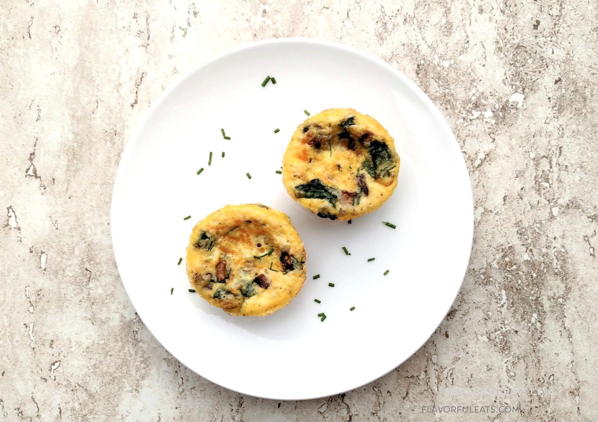 Two Spinach & Mushroom Muffin Pan Omelets on a white plate with chives.