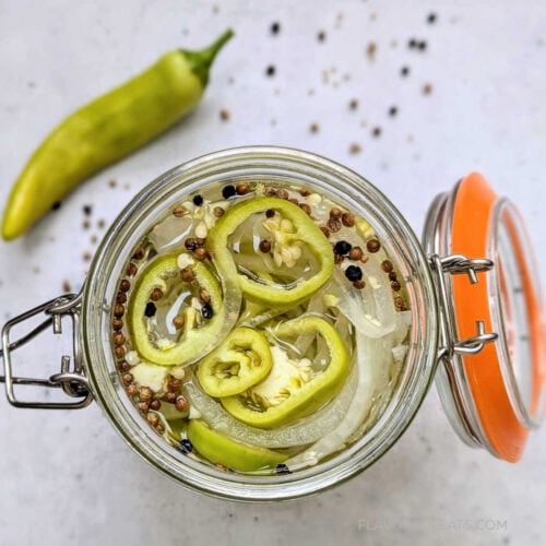 A top-down look into a jar of Pickled Hot Banana Peppers & Onions.