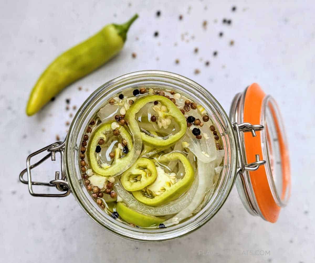 A top-down look into a jar of Pickled Hot Banana Peppers & Onions.