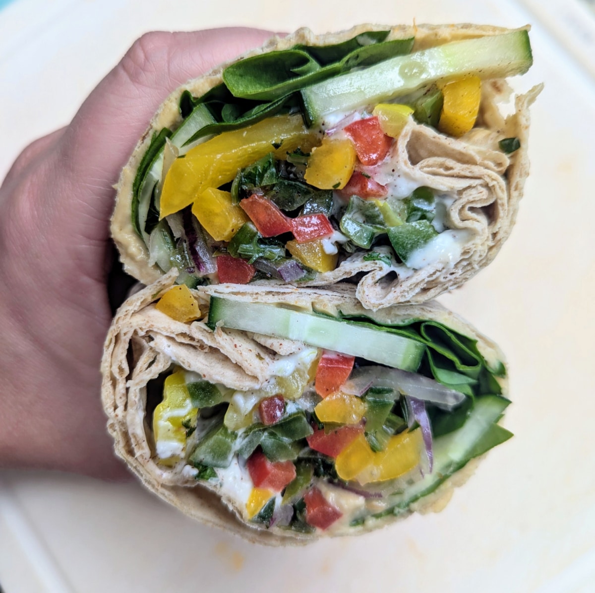 Mediterranean Hummus Veggie Wraps cut in half to show the inside.