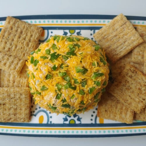 Cheddar Jalapeno Taco Cheese Ball on a platter with crackers.