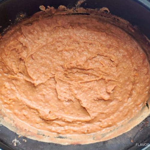 slow cooker with cooked refried beans blended smooth