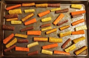 Curry Spiced Roasted Carrots on a baking sheet before they've cooked.