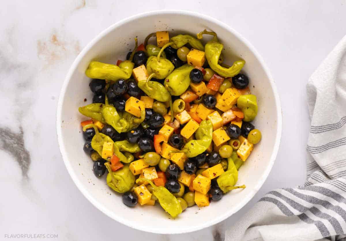 A large mixing bowl of Marinated Cheese & Olive Antipasto after it's prepared, before it's served.