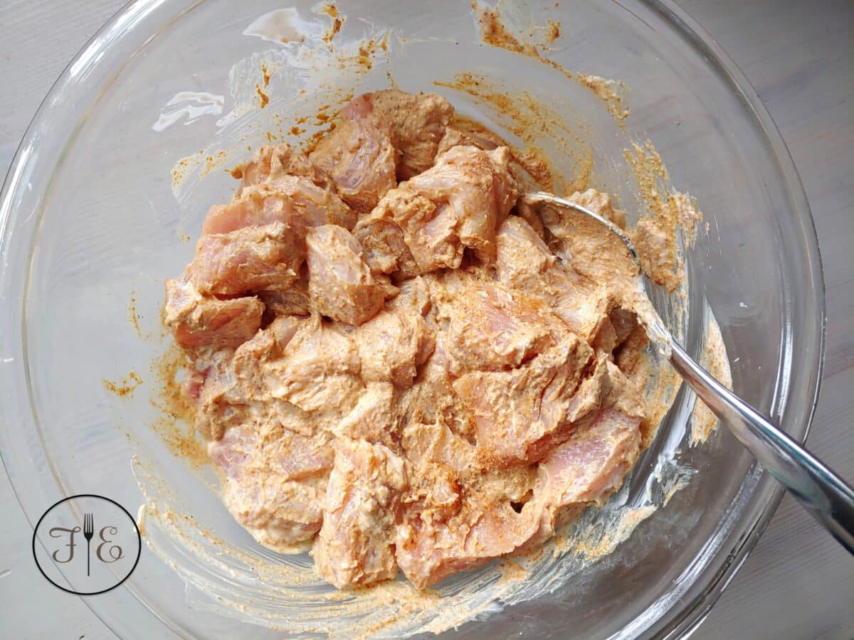 The chicken for Aji Amarillo Yogurt Marinated Chicken Kabobs marinating in a bowl.