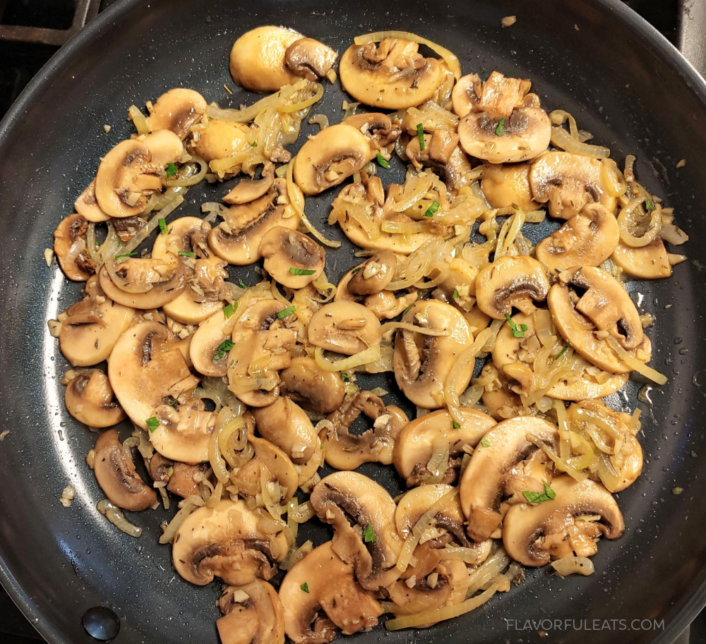 Mushrooms and onions sauteing in a pan