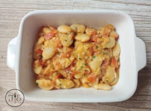 Sauteed White Beans with Tomatoes & Garlic in a rectangular dish.