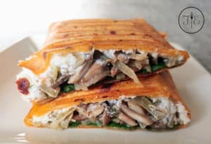 A Mushroom Goat Cheese Wrap cut in half to show the inside.