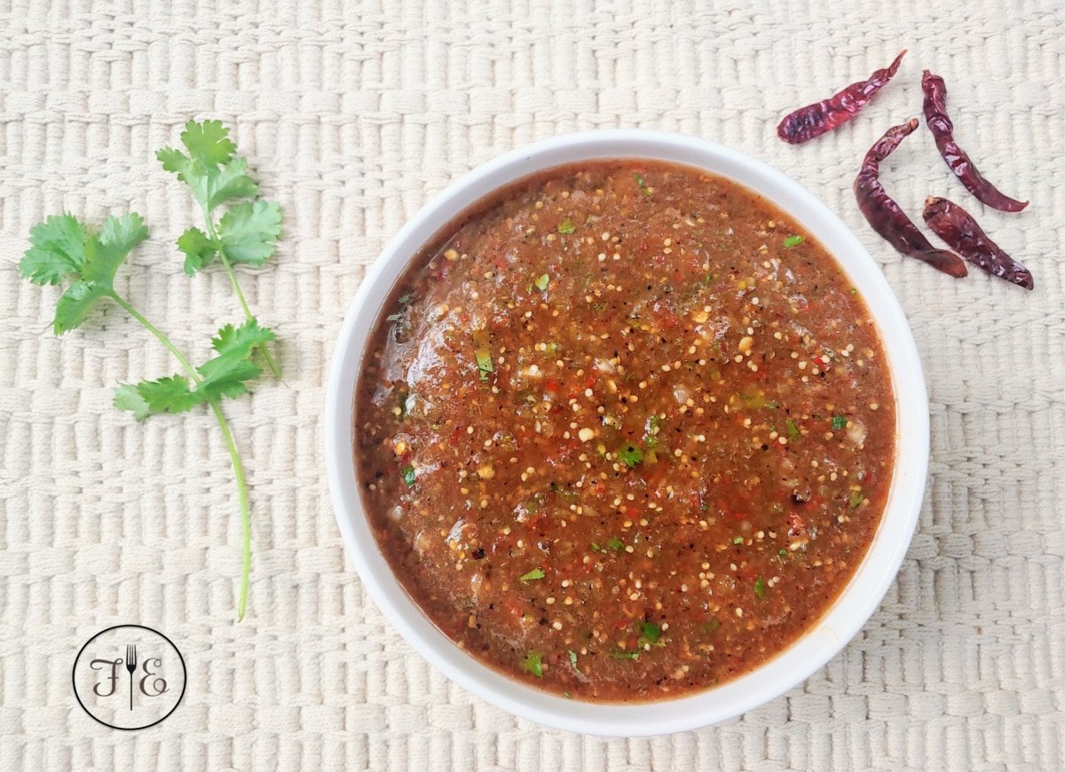 A white bowl full of Chile de Arbol Tomatillo Salsa.