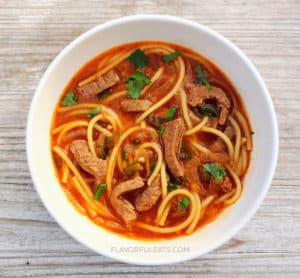 White bowl filled with Spicy Thai Beef Noodle Soup