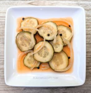 A white square plate with Sriracha Pickles on it.