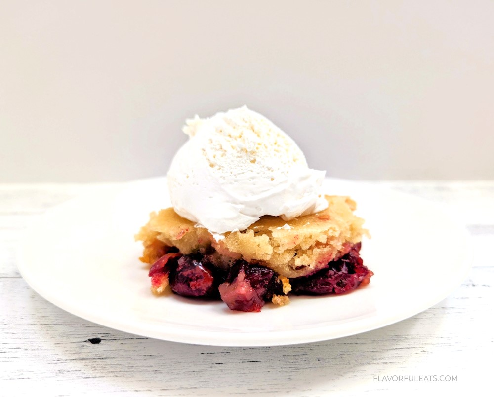 A serving of Slow Cooker Cranberry Cobbler with whipped cream on top