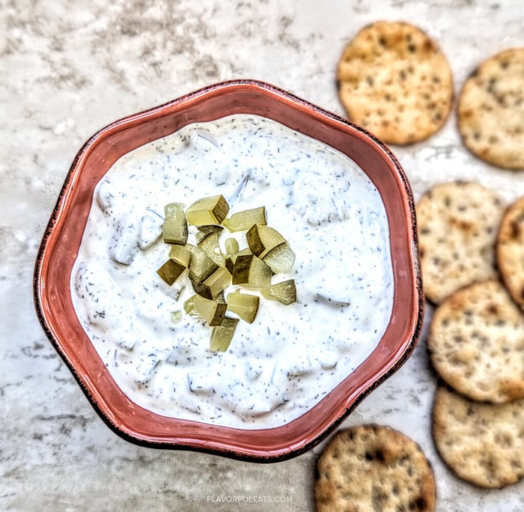 Bowl full of Dill Pickle Dip with crackers beside it