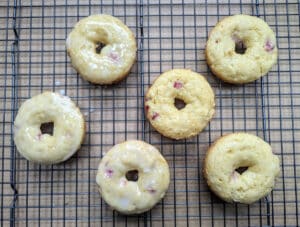 Donuts on wire rack showing some glazed and some not.