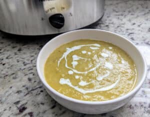 Slow Cooker Asparagus Leek Soup on kitchen counter with slow cooker behind it