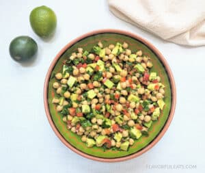 Chickpea Avocado Salad in a bowl with limes next to it
