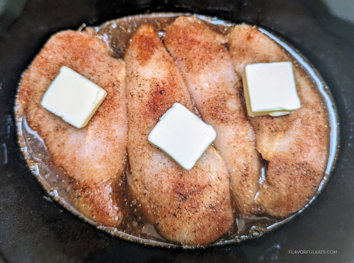 Chicken and butter in a slow cooker for Slow Cooker Chicken Sandwiches with Alabama White Sauce