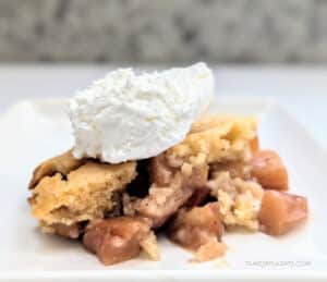 A serving of Slow Cooker Apple Cobbler on a white plate.