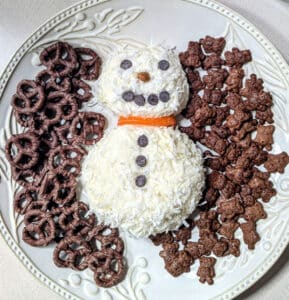 Coconut Snowman Cheese Ball on large white platter with dippers.