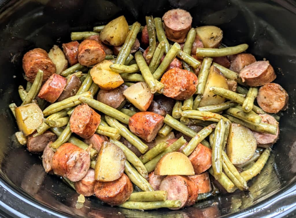 Slow Cooker Cajun Sausage, Green Beans, and Potatoes shown all cooked in a slow cooker