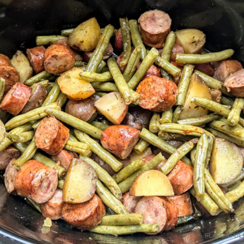 Slow Cooker Cajun Sausage, Green Beans, and Potatoes shown all cooked in a slow cooker