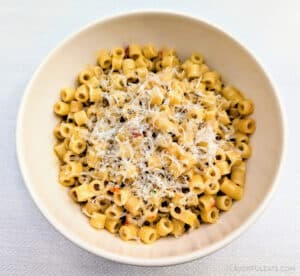 A white bowl filled with Calabrian Chili Butter Ditalini Pasta (One-Pan Recipe) with grated parmesan cheese on top