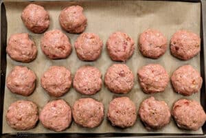 Baked Sun-Dried Tomato Turkey Meatballs on a sheet pan before they've baked.