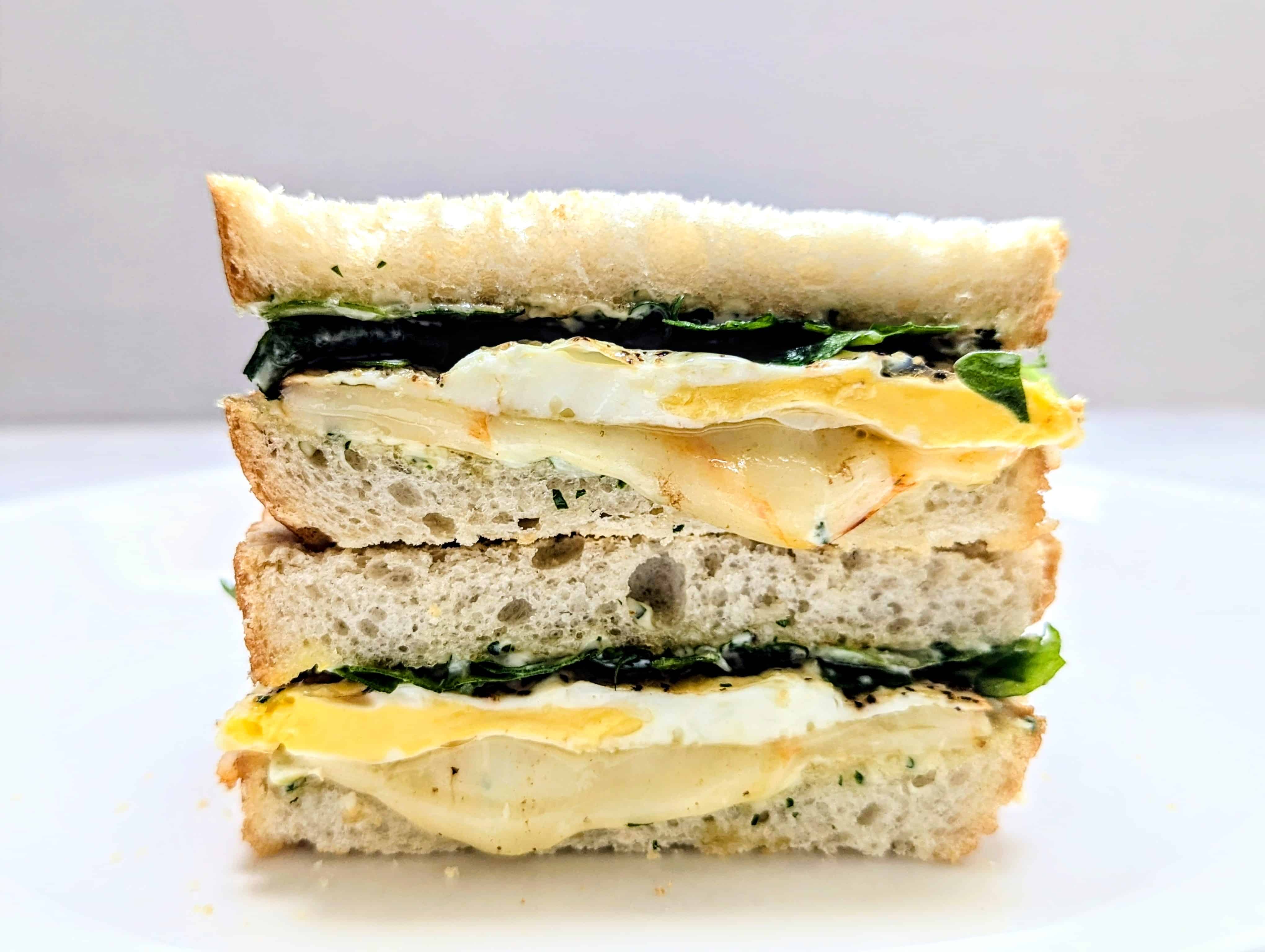 Fried Egg Sandwich with Herby Mayo cut in half and stacked on top of each other.