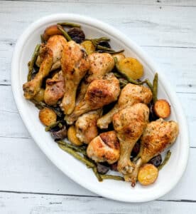 Sheet Pan Chicken Drumsticks, Potatoes & Green Beans on a white serving platter.