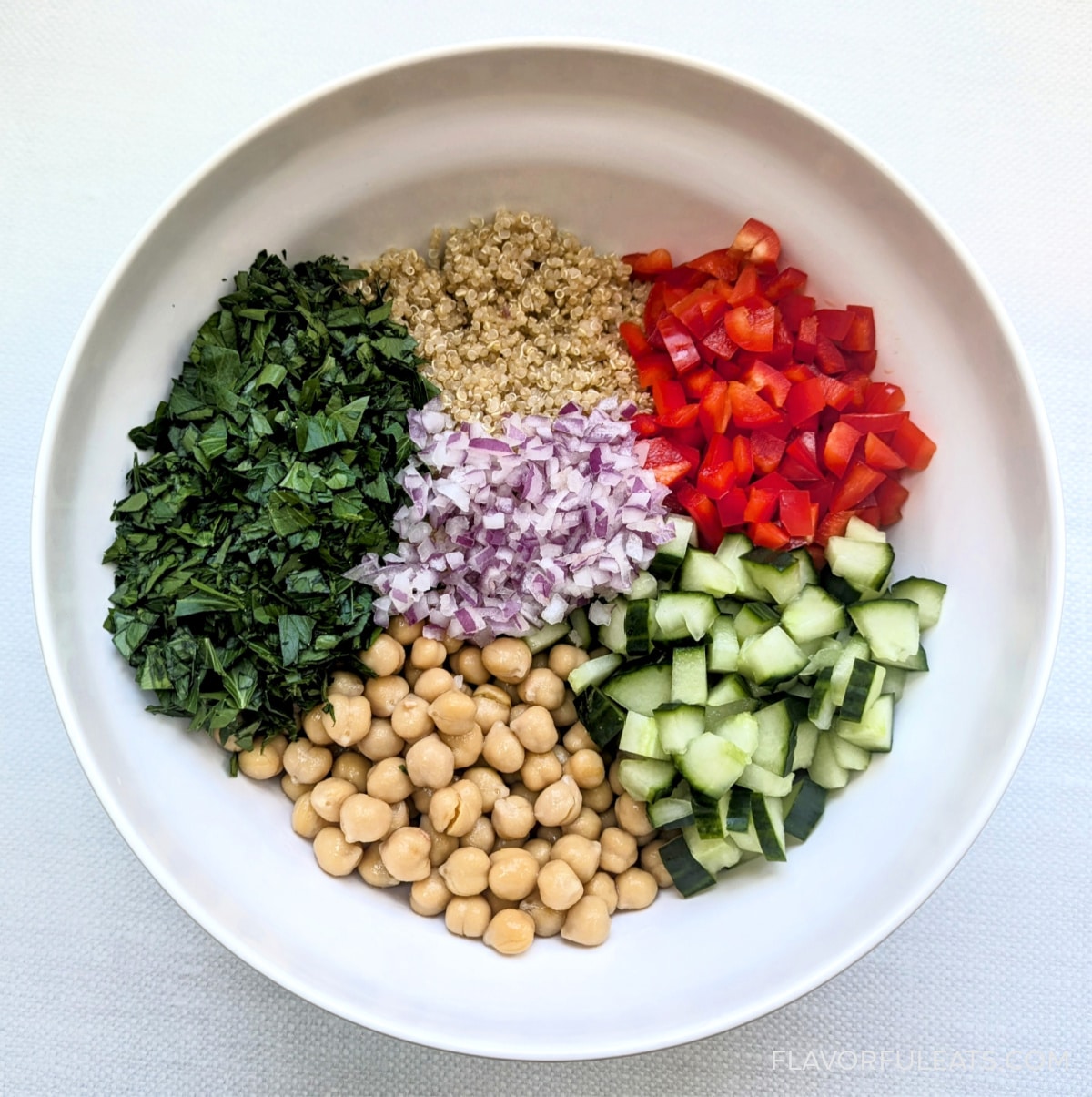 Ingredients for Lemony Quinoa Chickpea Salad in a bowl before they're combined.