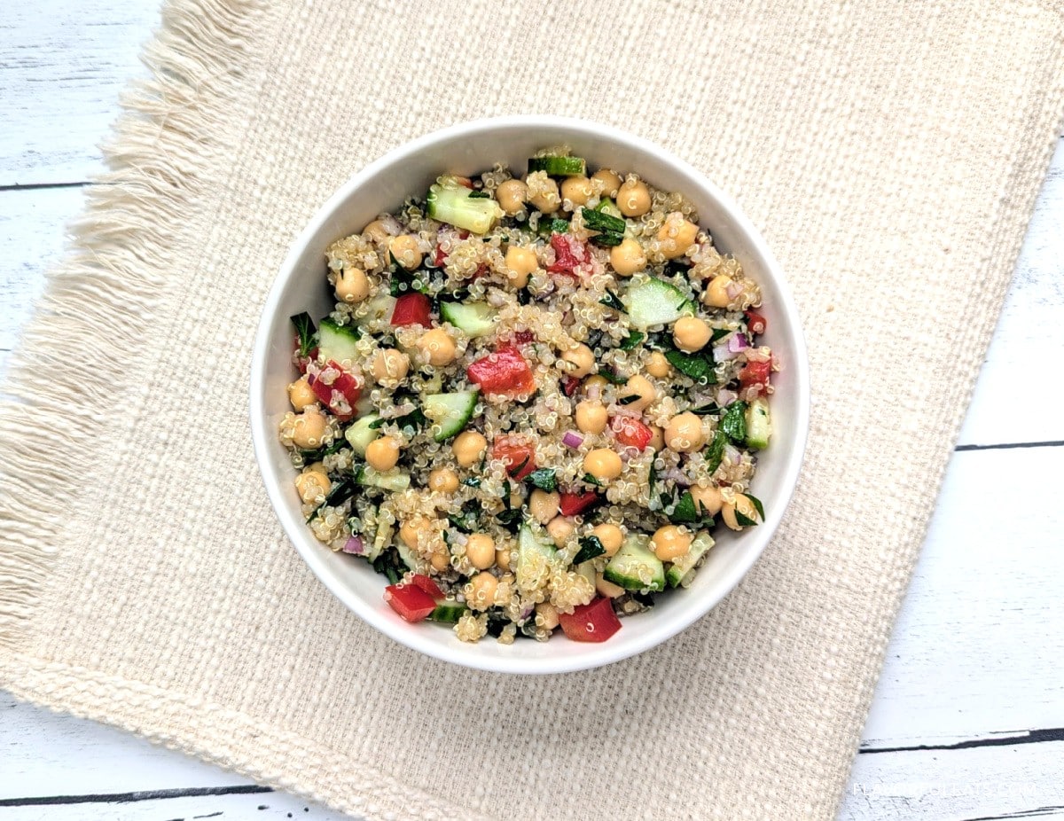 Lemony Quinoa Chickpea Salad in a white bowl on a placemat.