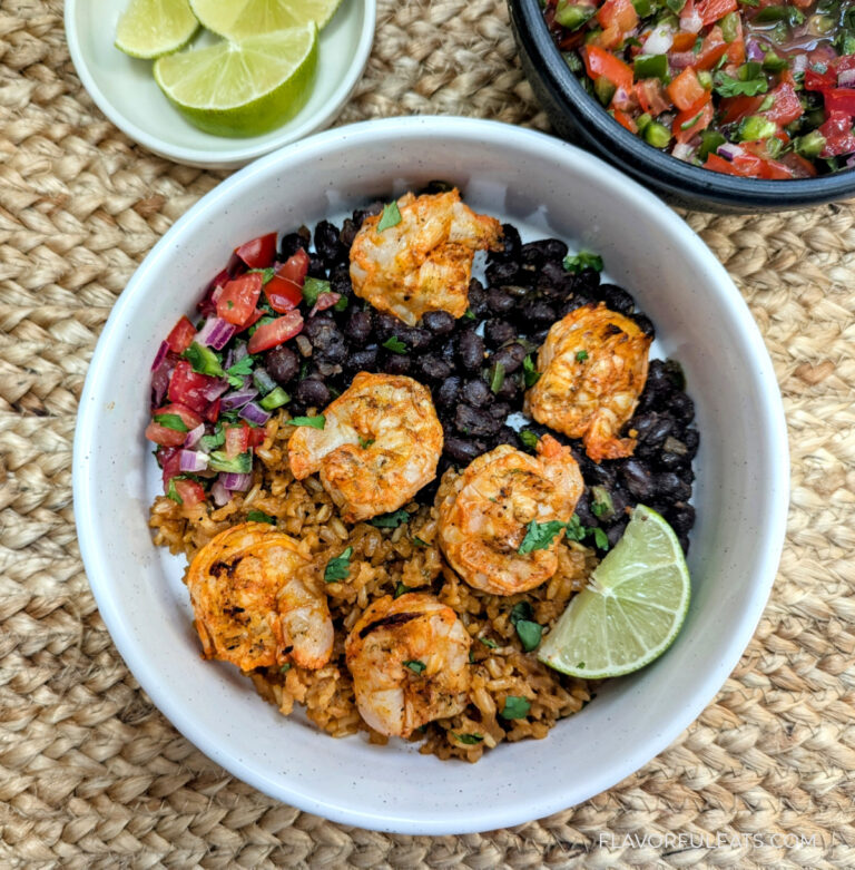Achiote Shrimp Skewers in a burrito bowl with Mexican rice, black beans, and pico de gallo.