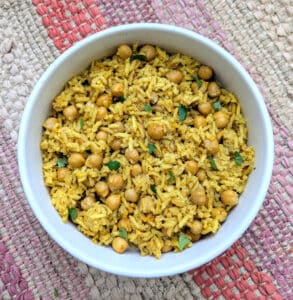 One-Pot Spiced Rice and Chickpeas in a white bowl on a colorful Indian placemat.