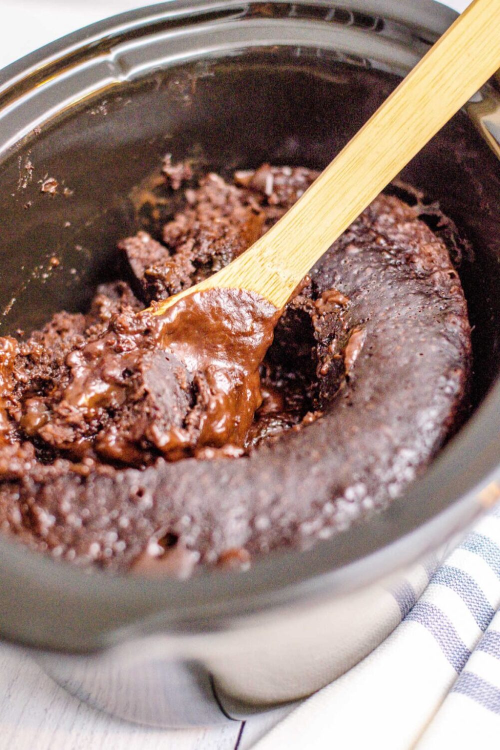 Crockpot Chocolate Lava Cake in a slow cooker with a spoon scooping some out.
