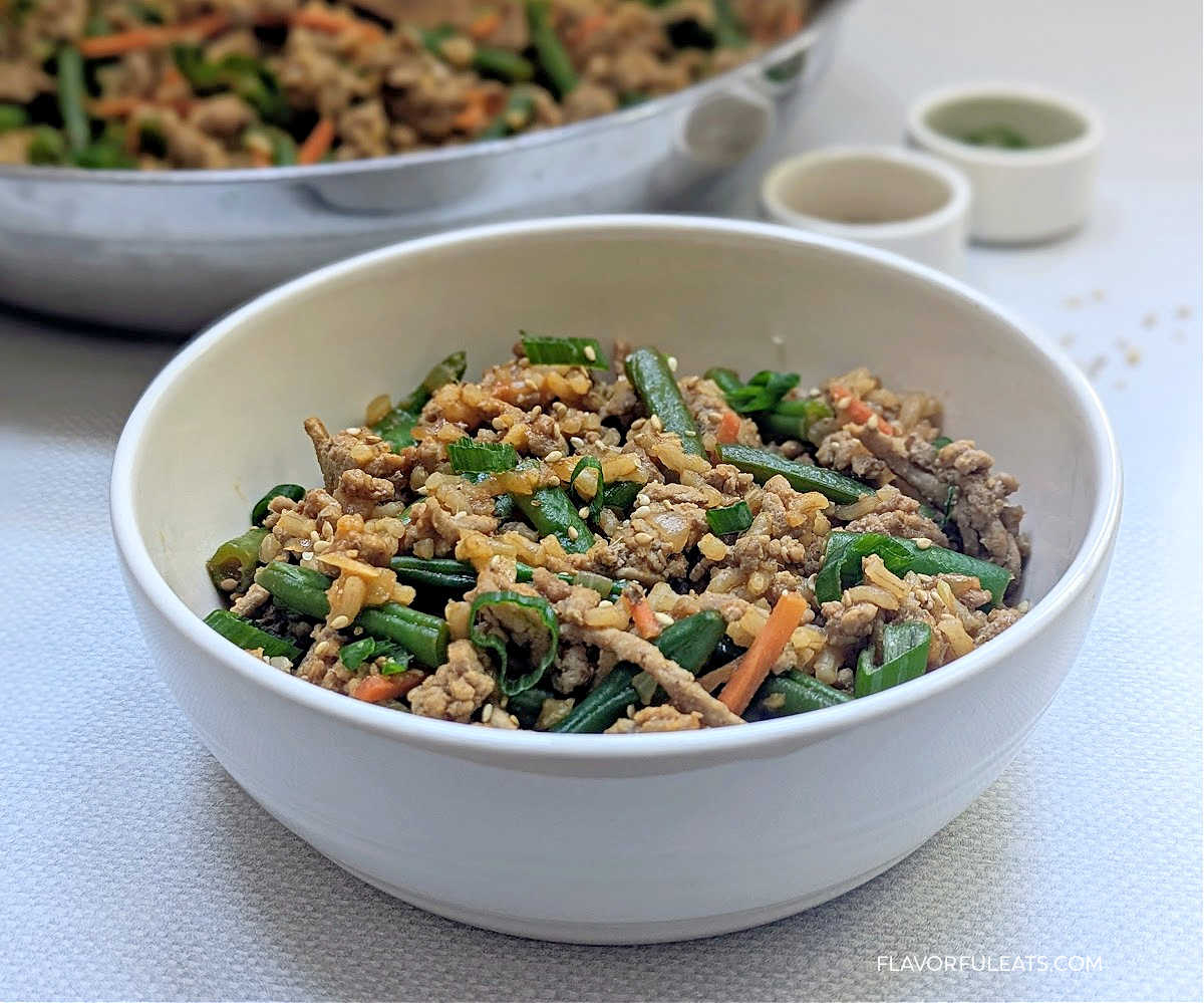 Gochujang Ground Turkey, Rice & Green Bean Skillet in a bowl with the pan in the background.