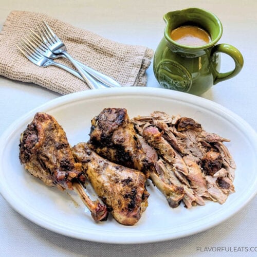 Slow Cooker Turkey Legs with Onion Gravy on a platter with the gravy boat beside it.