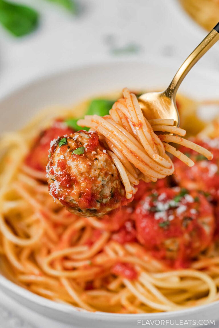 Baked Turkey, Zucchini & Feta Meatballs on a fork with spaghetti.