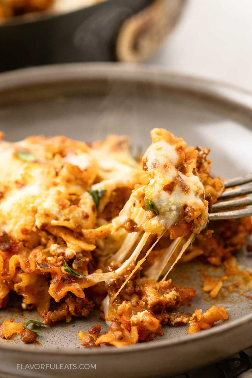 A fork with a bite of One-Pan Cheesy Lasagna Skillet on it.