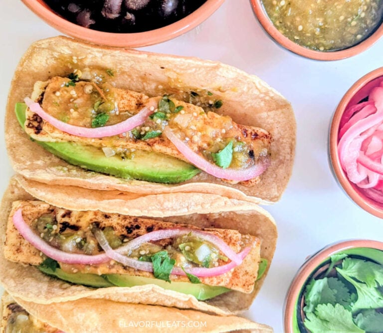 An up close photo of Panela Cheese Tacos with condiments beside them.