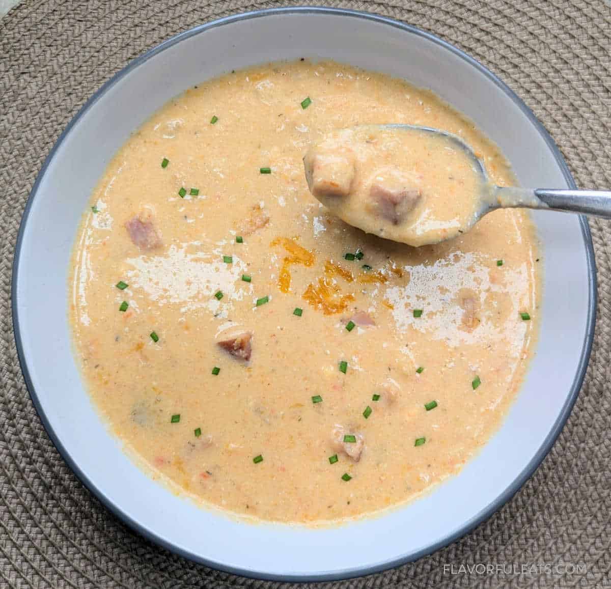 Slow Cooker Cheesy Ham & Cauliflower Soup in a bowl with a spoon.