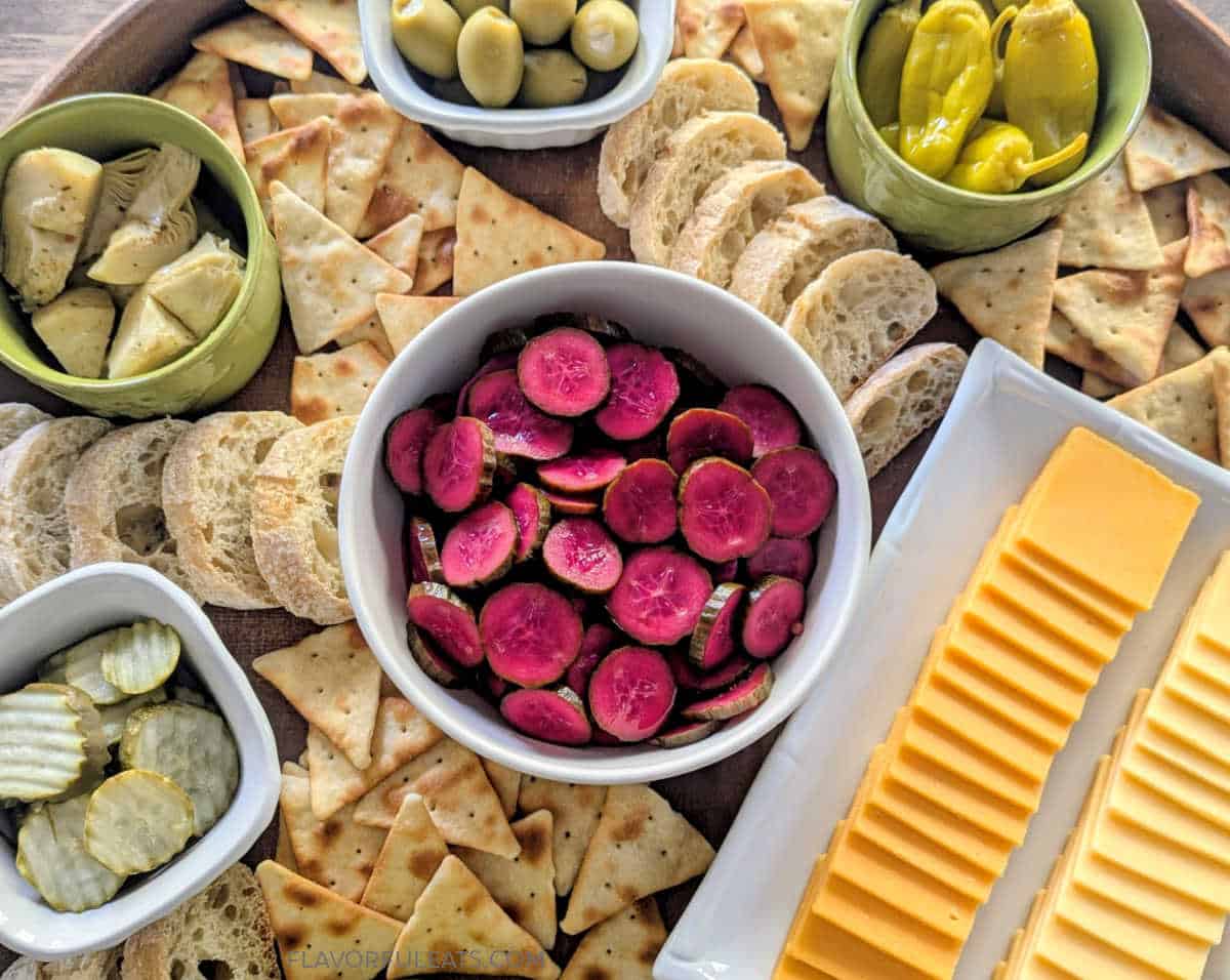Pink Pickled Cucumbers up close on a charcuterie platter.
