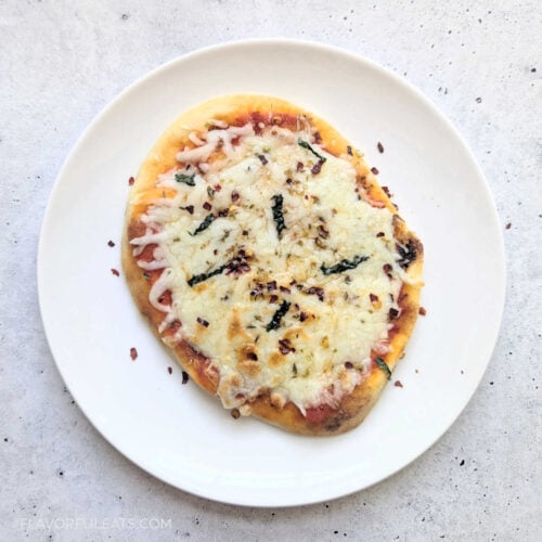 An Air Fryer Mini Naan Pizza on a white plate.