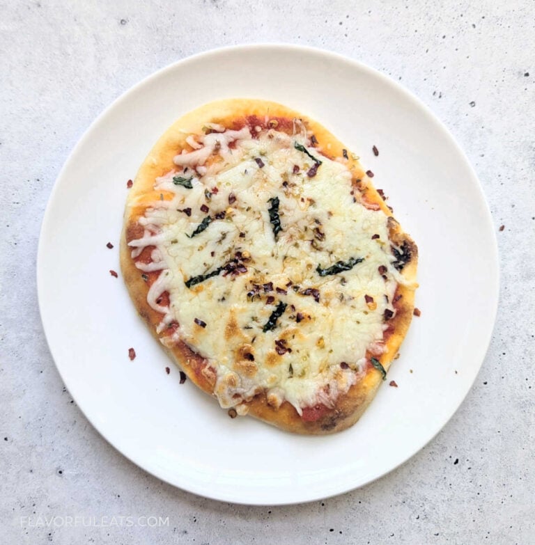 An Air Fryer Mini Naan Pizza on a white plate.