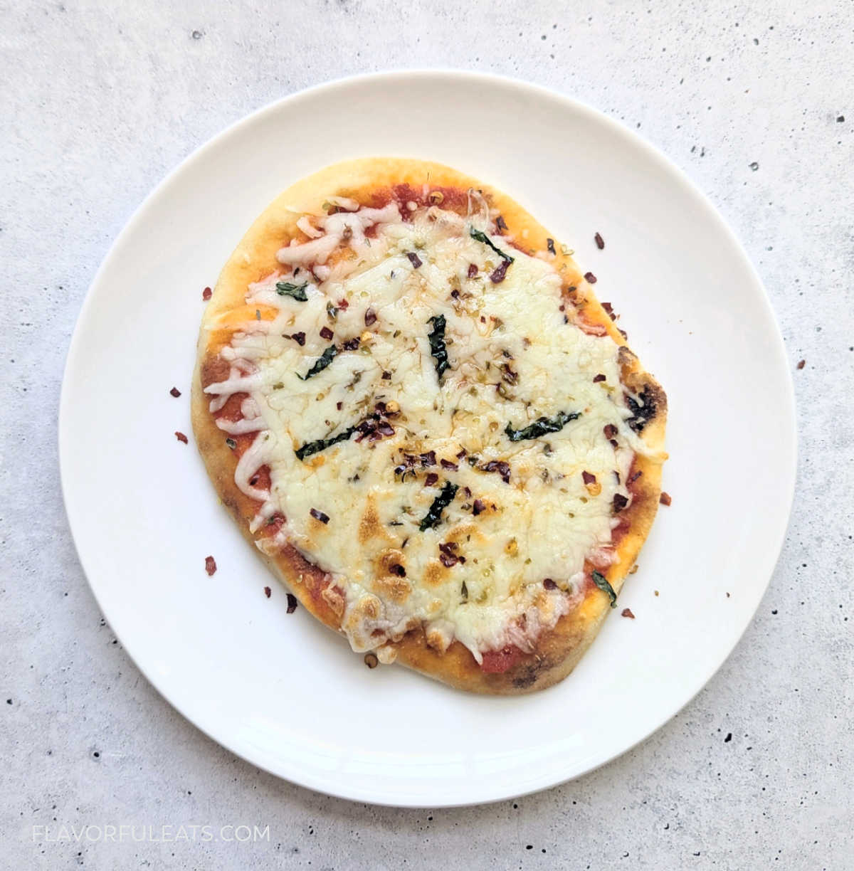 An Air Fryer Mini Naan Pizza on a white plate.