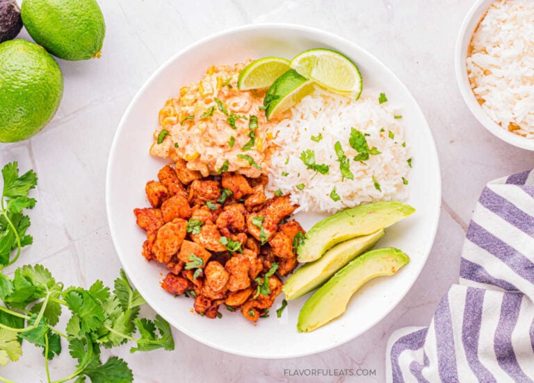 Mexican Street Corn Chicken Bowls in a white bowl with esquites (Mexican street corn), rice, and avocado.