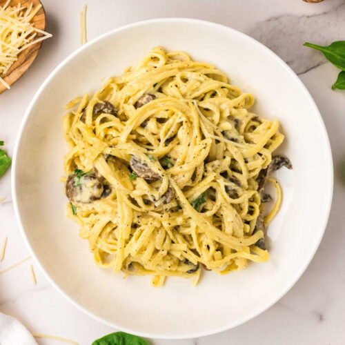 One-Pan Creamy Mushroom & Spinach Pasta plated with Parmesan cheese.